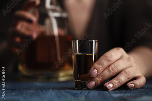 Woman sitting at home drinking way too much whiskey, she is addicted