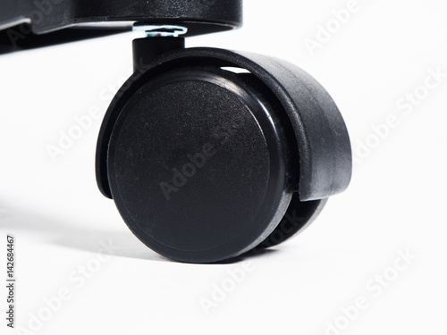 Black plastic furniture wheel over white background