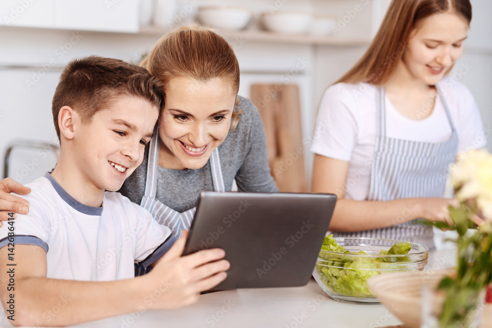 Positive single parent family resting in the kitchen Positive single parent family resting in the kitchen
