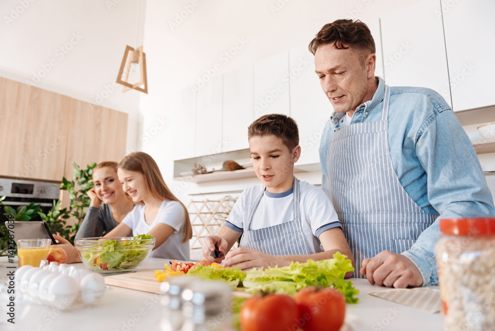 Concentrated boy cooking with his father Concentrated boy cooking with his father