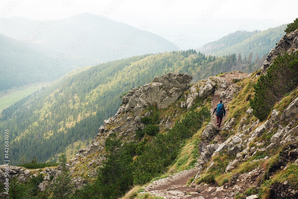 Hiker trekking aone along a rock mountain path