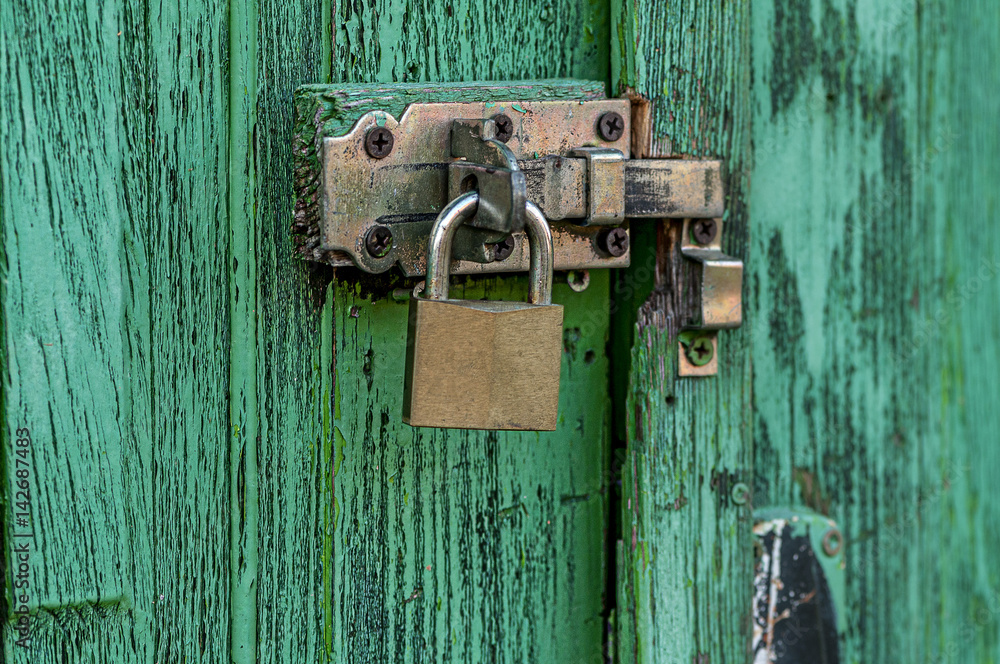 Old lock on a weathered door. Texture background. Old lock on a weathered door. Texture background.