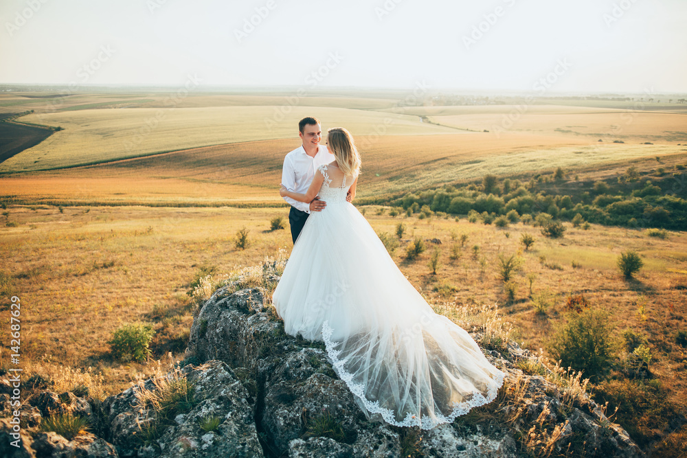 stylish gorgeous couple newlyweds standing on the rocks in the mountains