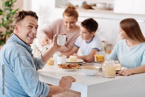 Cheeful man having breakfast with his family