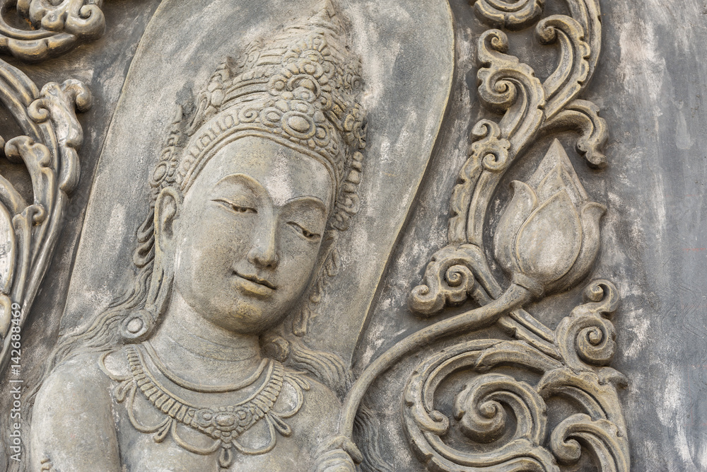 Black and white picture of Buddha statue. Buddha's face on wall