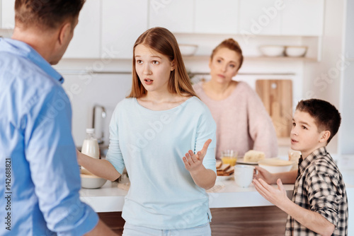 Young nervous girl quarrelling with her father