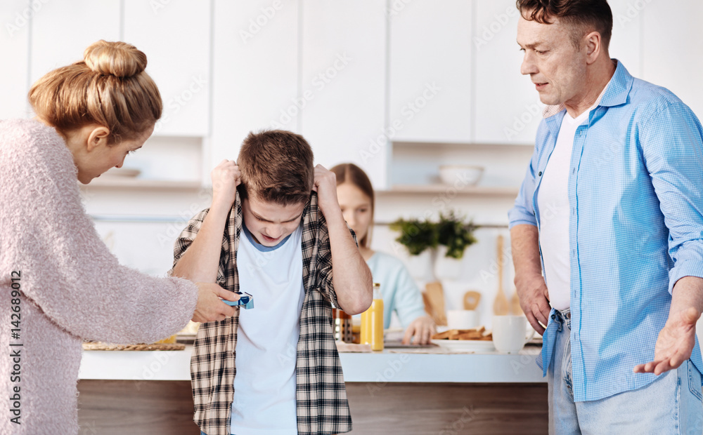 Obraz premium Carign furious parents punishing their son for smoking