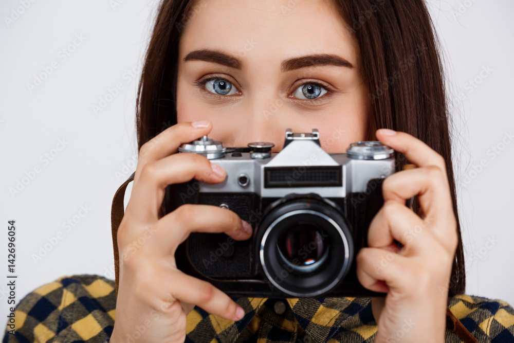 Close up portrait of young beautiful brunette photographer over white background. Close up portrait of young beautiful brunette photographer over white background.