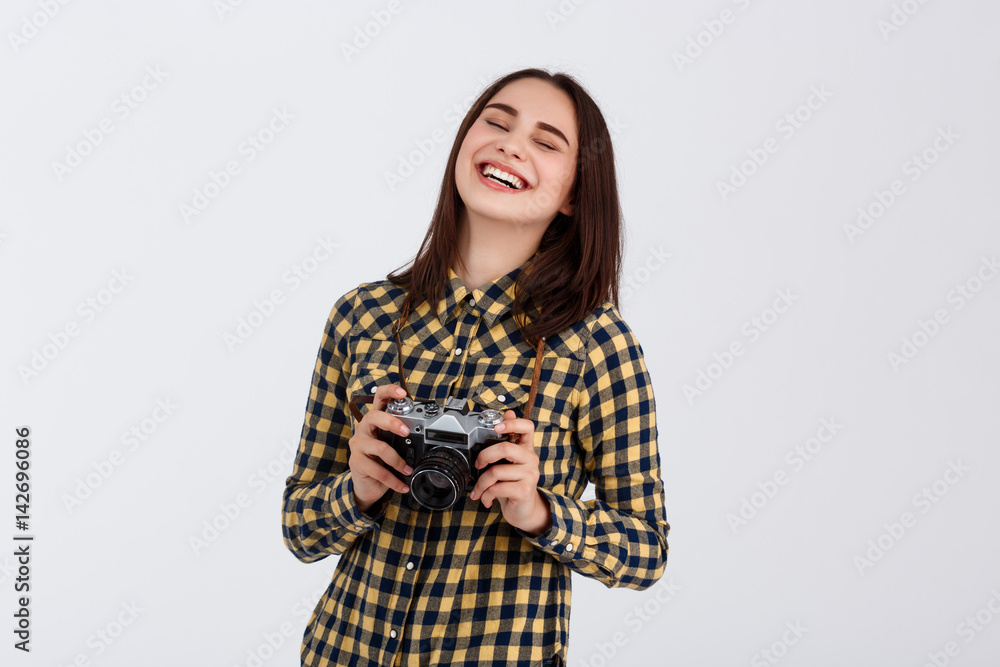 Young beautiful smiling brunette photographer over white background. Young beautiful smiling brunette photographer over white background.