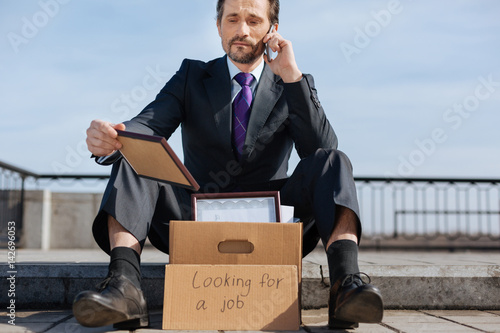 Upset jobless male holding his reward