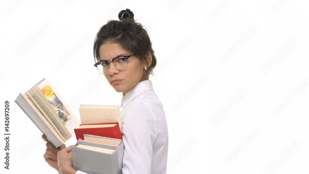 Serious young woman employee or student carrying books and reading isolated Serious young woman employee or student carrying books and reading isolated