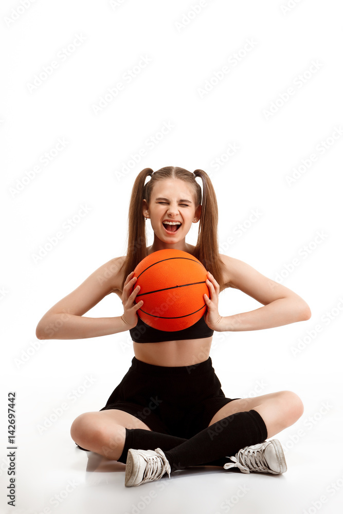 Young pretty girl posing with basketball over white background. Young pretty girl posing with basketball over white background.