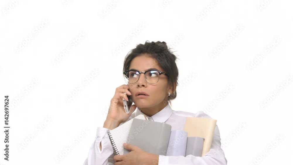 Happy smiling student girl talking on mobile phone while holding stack of books isolated Happy smiling student girl talking on mobile phone while holding stack of books isolated