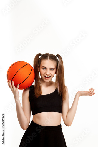 Young pretty girl posing with basketball, isolated on white background.