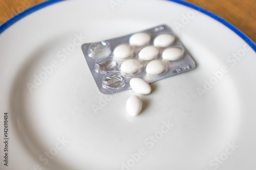 Set of pills in a plastic and foil package, on tray