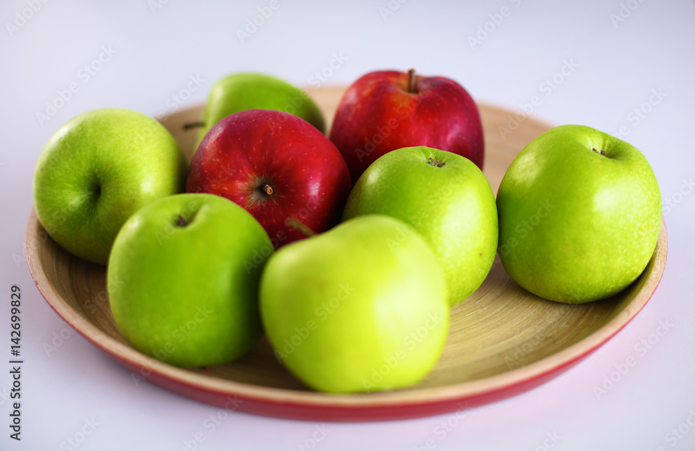Still life arrangement of apples on a wooden platter