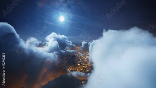 Flying over the deep night timelapse clouds with moon light. Seamlessly looped animation. Flight through moving cloudscape over night city lights. Perfect for cinema, background, digital composition.