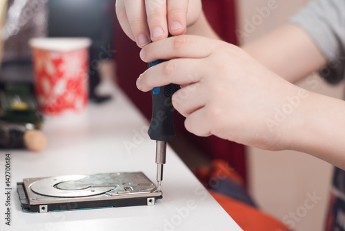 Hands of a little boy with the screwdriver,