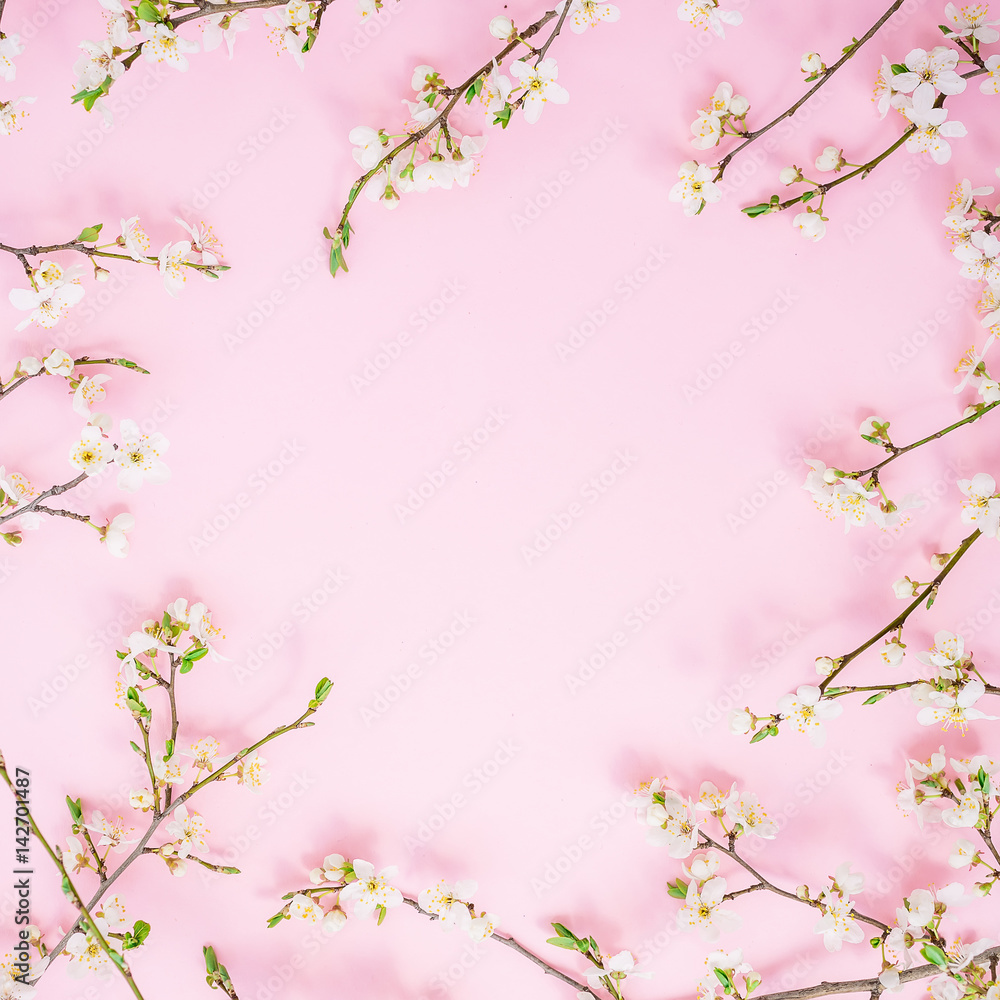 Frame of spring flowers on pink background. Flat lay, top view. Spring time background.