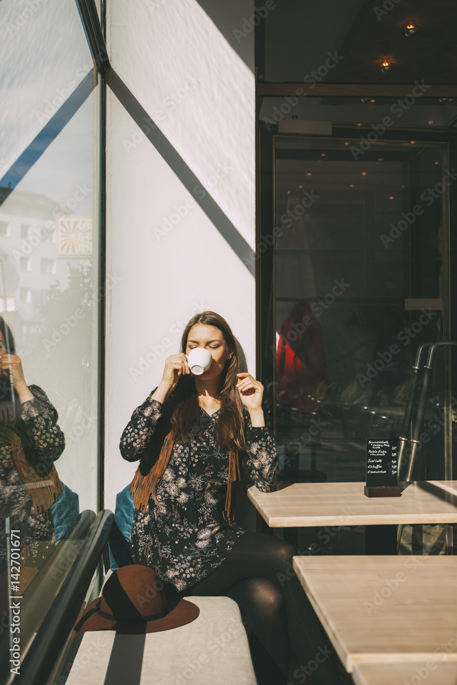 Woman sitting in a coffee shop drinking coffee Woman sitting in a coffee shop drinking coffee