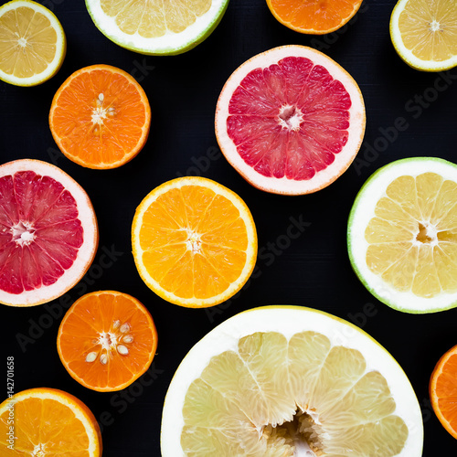 Lemon, orange, mandarin, grapefruit and sweetie on black background. Flat lay, top view. Fruit background