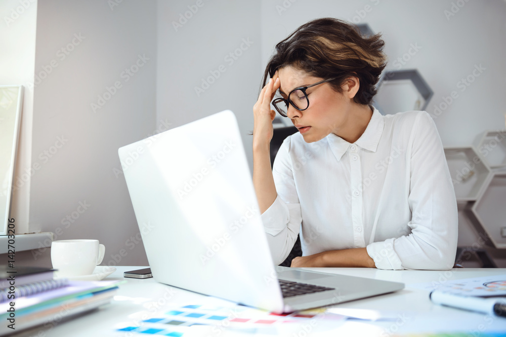 Young beautiful businesswoman working with laptop at workplace in office. Young beautiful businesswoman working with laptop at workplace in office.