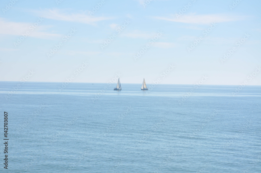 Yachts and boats sailing along the calm water of the Mediterranean Sea during the day