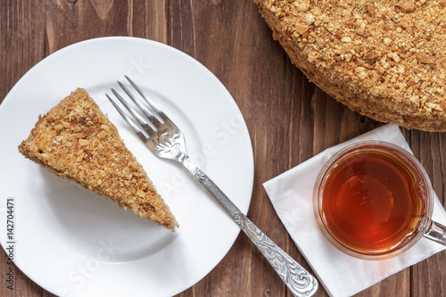 Round cake napoleon with tea on a wooden background. photo