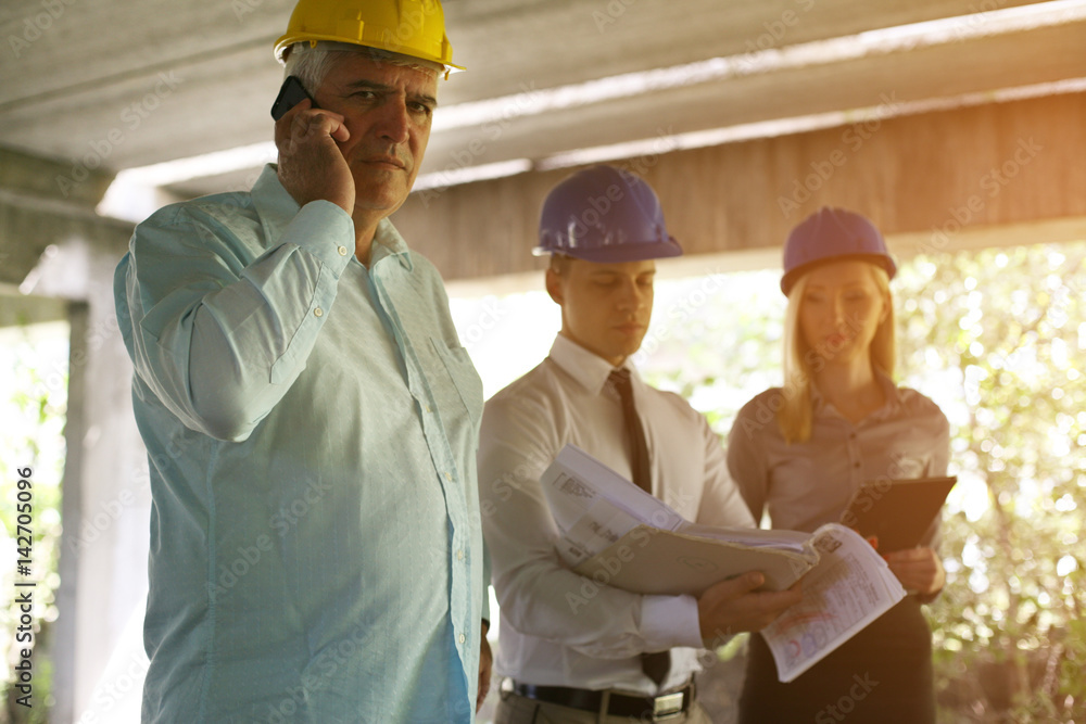 Senior architect talking on smart phone. Senior architect talking on smart phone.