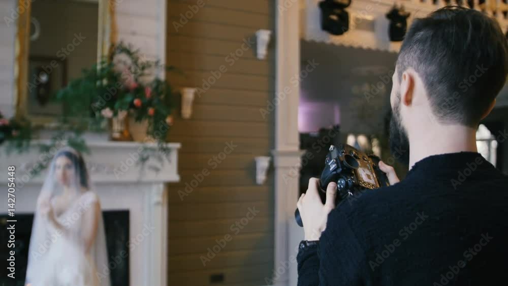 photographer shooting bride with a fireplace on the background photographer shooting bride with a fireplace on the background