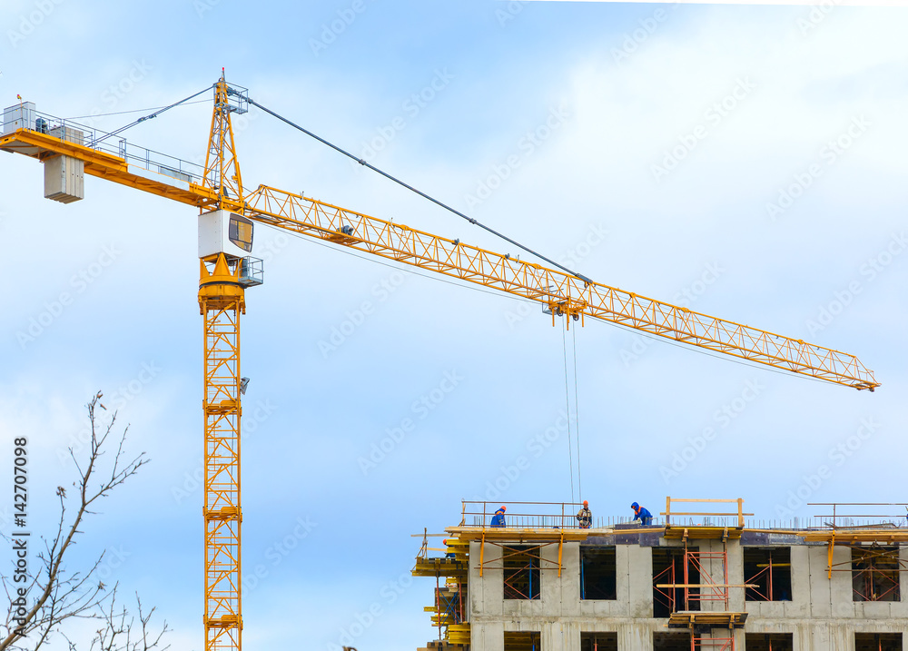 Crane and workers at construction of residental building. Crane and workers at construction of residental building.