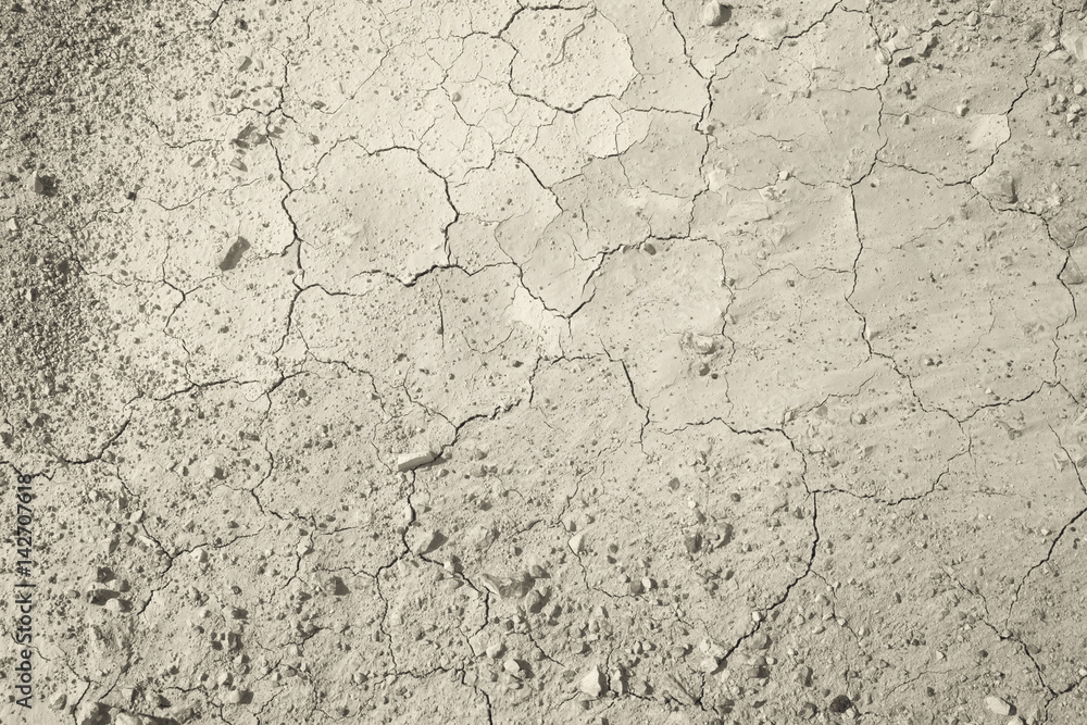 Top view of cracked and barren ground, clay desert texture.Color toned. Top view of cracked and barren ground, clay desert texture.Color toned.