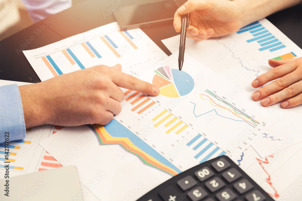 business colleague discussing paperwork graphs and charts