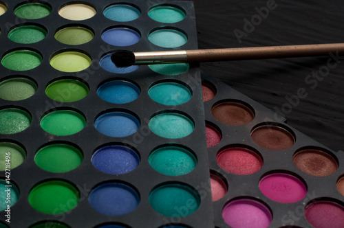 Palette of professional colorful eye shadows. Collection of multicolor eyeshadows. Makeup set background.