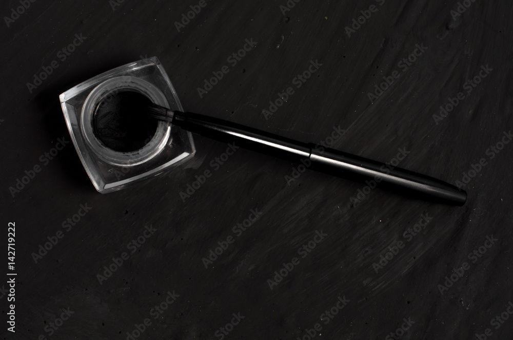Eyeliner and brush on black background. Eyeliner and brush on black background.