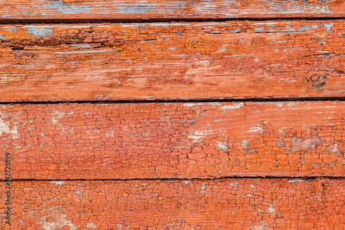 Rustic vintage wooden wall with faded red paint. Background, texture.