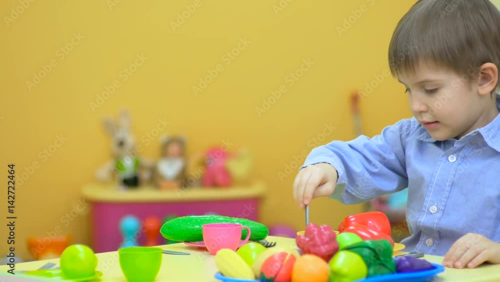 Little kid playing with plastic toys in children's room Little kid playing with plastic toys in children's room