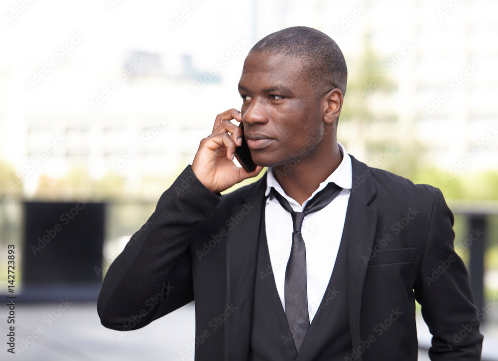 Full length portrait of a confident young businessman walking in the city talking on cell phone Full length portrait of a confident young businessman walking in the city talking on cell phone