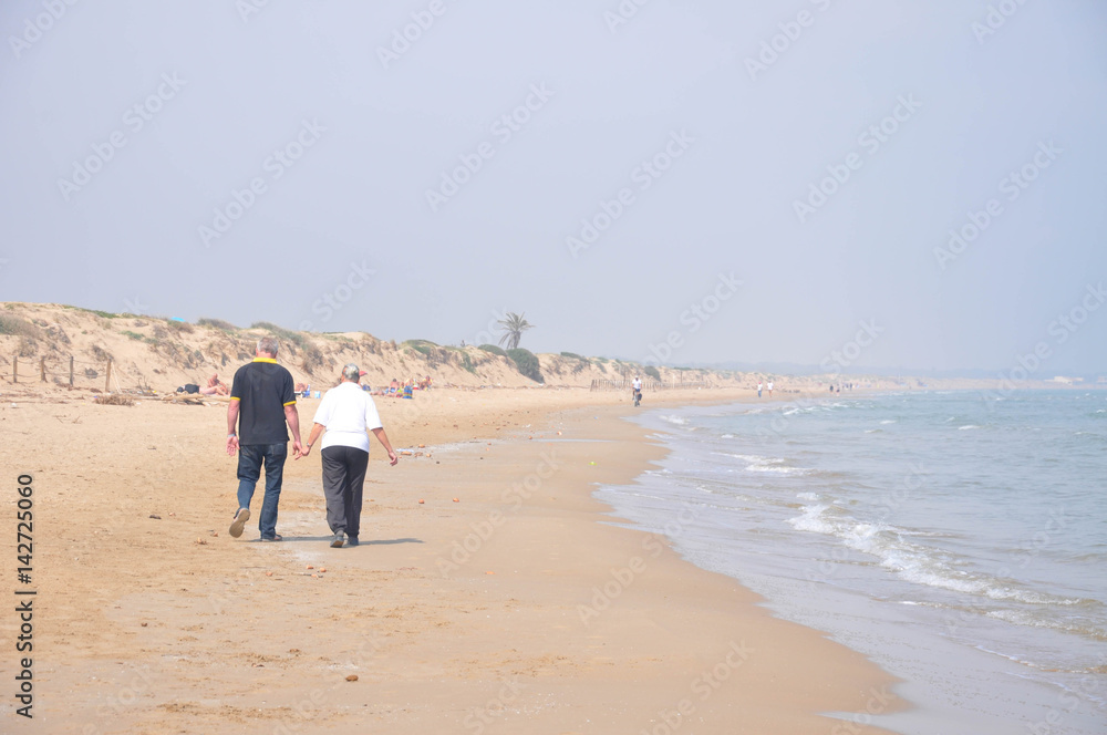 People strolling by the sea on a sunny day