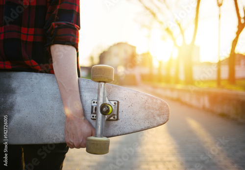 Rear view of skateboard girl holding skateboard