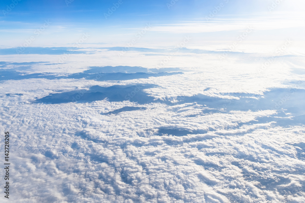 View from airplane window above the clouds