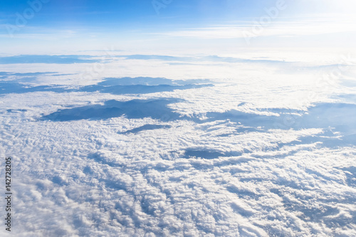 View from airplane window above the clouds