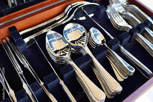 Cutlery forks, spoons and knives on dark blue velvet