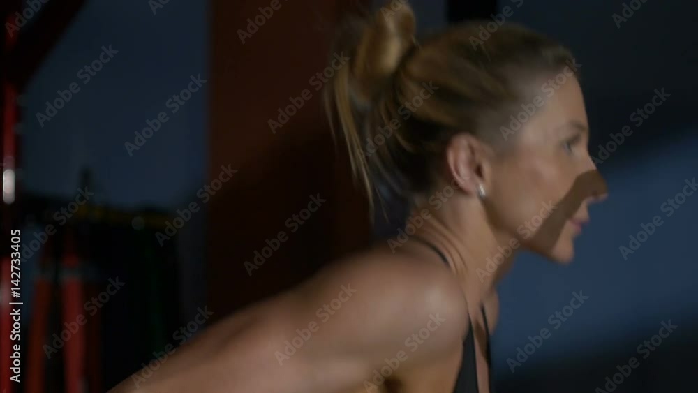 The woman in sportswear does push-ups in a gym, people training in fitness club, girl and sports The woman in sportswear does push-ups in a gym, people training in fitness club, girl and sports