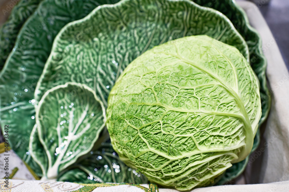 Fototapeta premium Cabbage and dish in form of green leaf