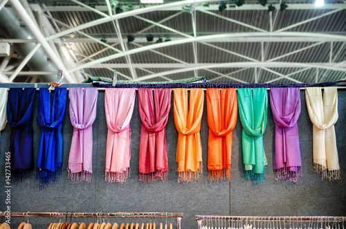 many pashmina foulards hanging from a market stall photo