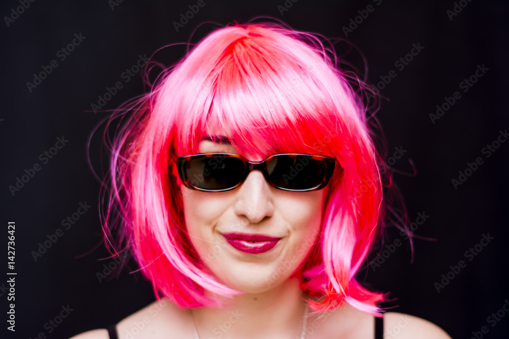 Naklejka premium Beauty Woman With Pink Wig And Sunglasses Over Black Background