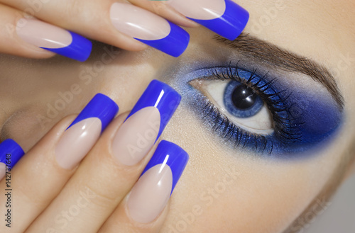 Close up  portrait of  young woman with big blue eyes  and prefect manicure. Fashion make up.