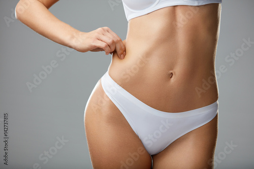 Weight Loss. Closeup Of Hot Sexy Female With Hand Pinching Skin photo