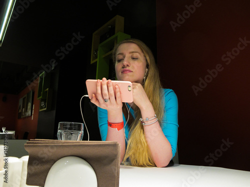 Young woman listening to music at the table